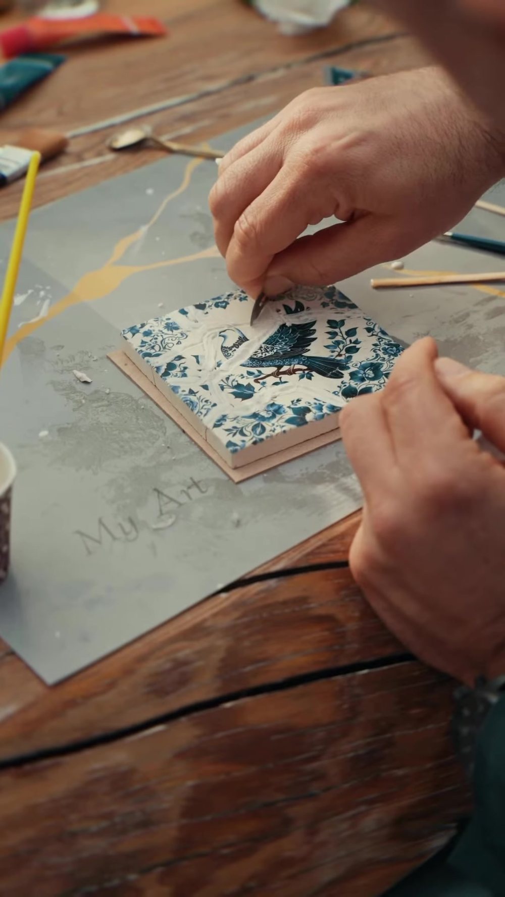 Tracing a crack in gold on a blue-veya-white tile